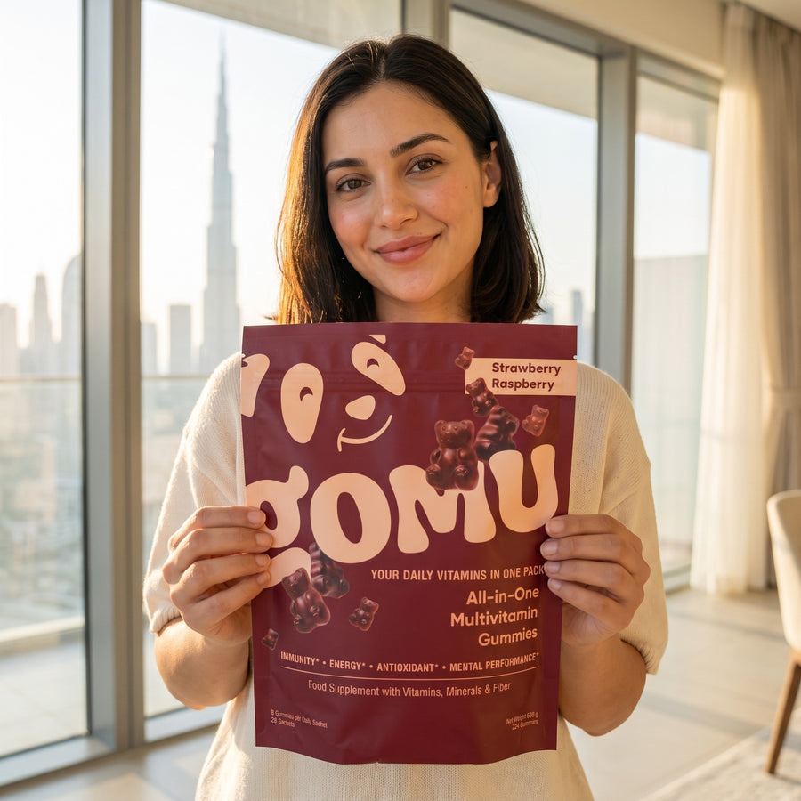 Woman holding a GOMU multivitamin gummies pouch at home in Dubai