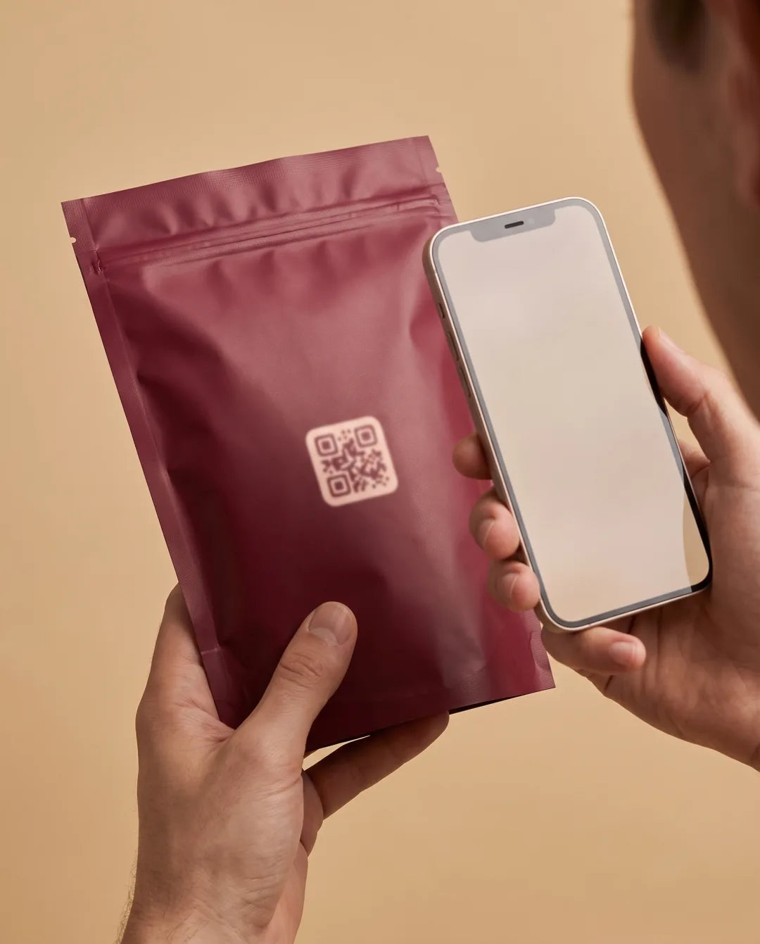 Hands scanning the QR code on the back of the GOMU pouch with a phone